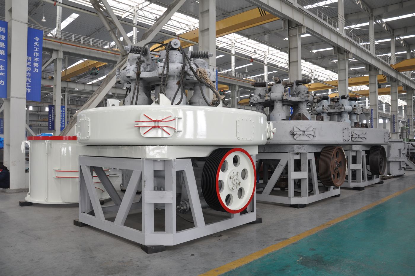 Three assembled mills standing side by side on the workshop floor.